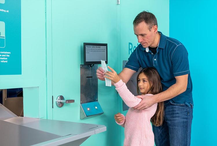 Young child and father returning bottles and cans electronically