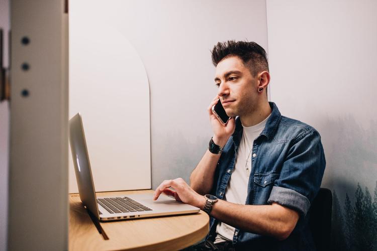 Man sitting at a table talking on the phone