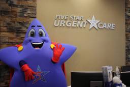 Photo of Five Star Urgent Care mascot waving in front of the office