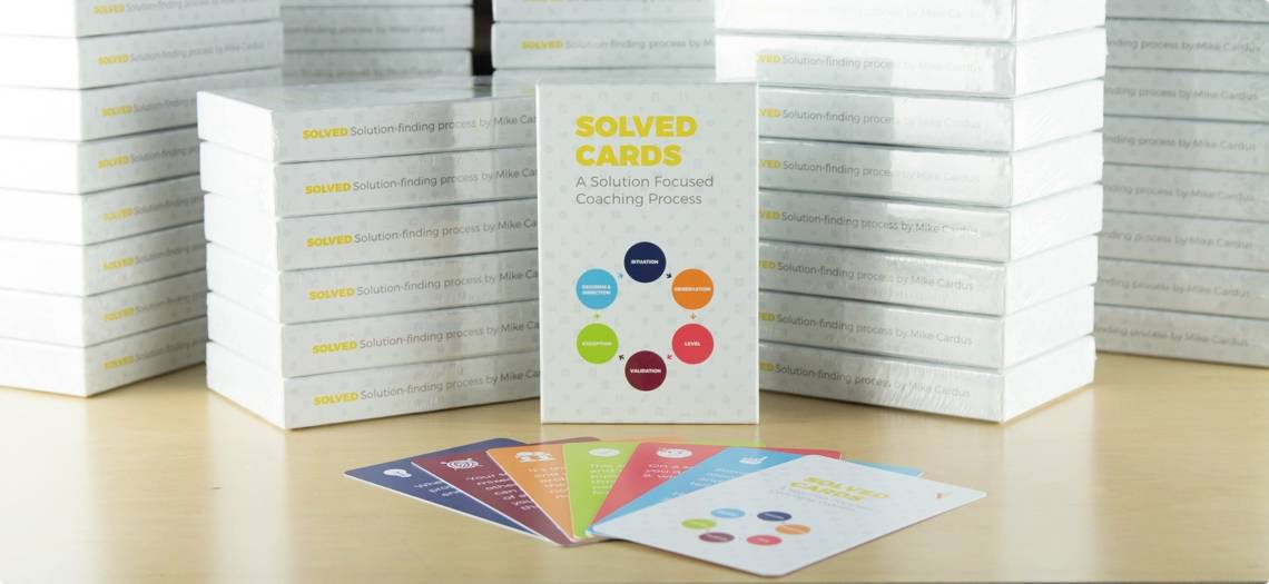 stack of white boxes with colorful cards splayed out in front
