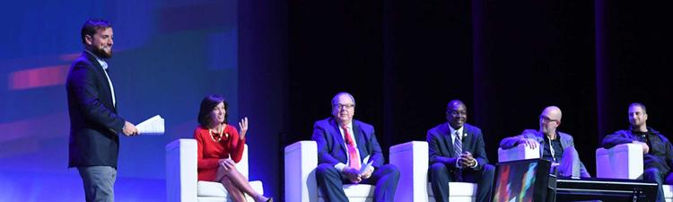 professionals seated on stage with lighting