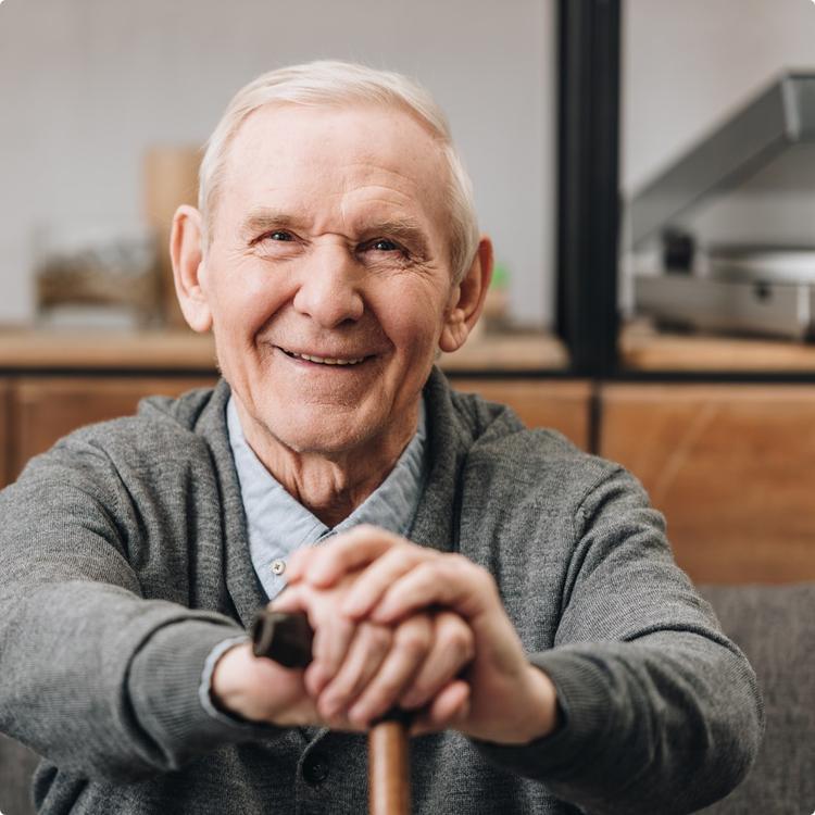 older man smiling look at camera with cane
